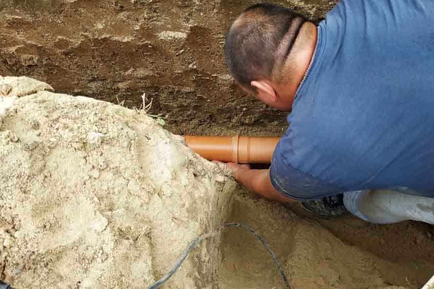 man replacing sewer line